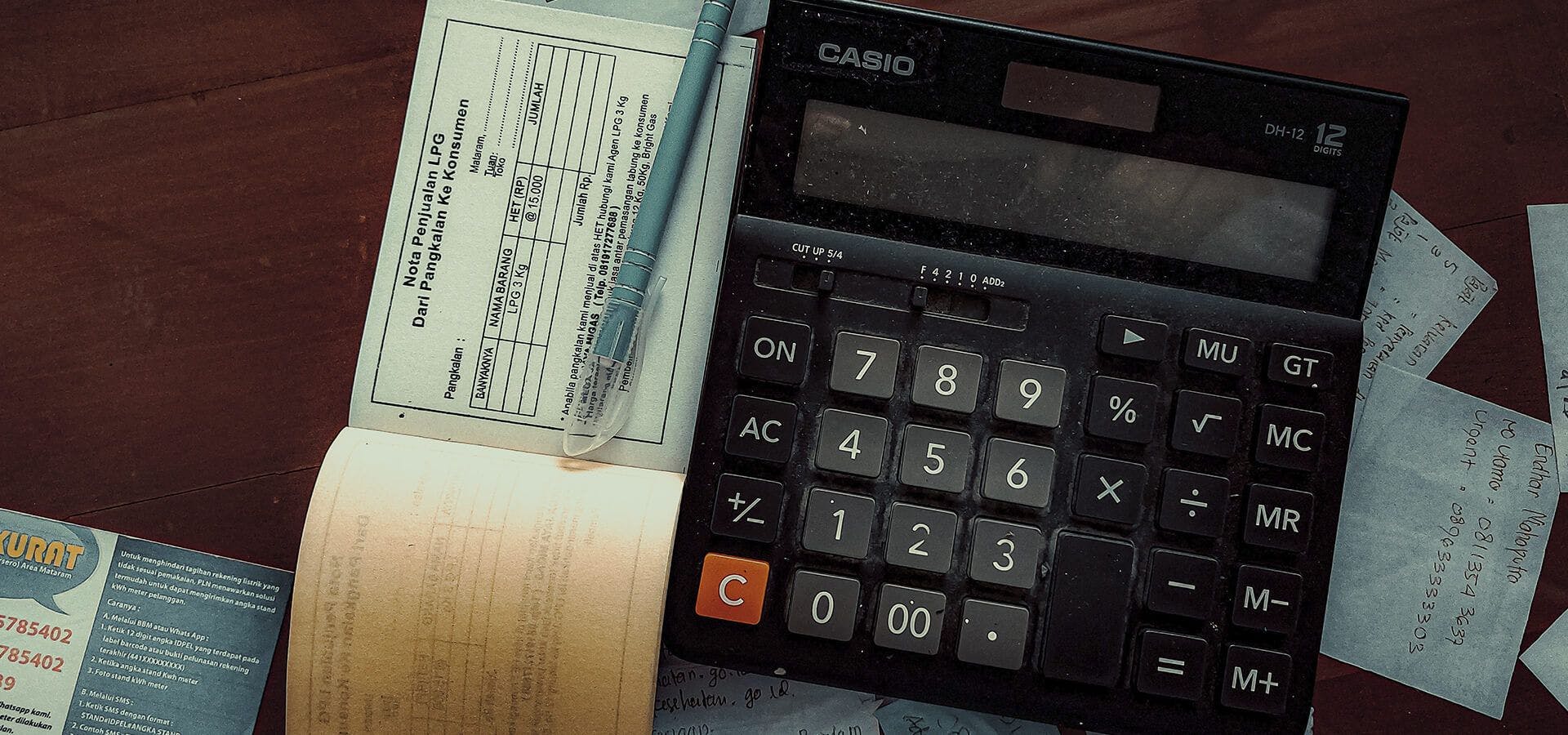 Calculadora antigua y papeles sobre un escritorio